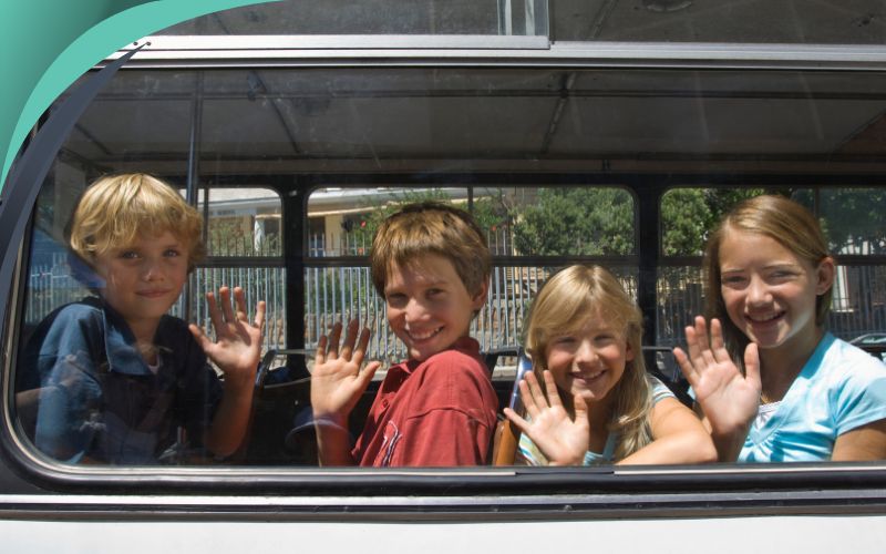 children waving from inside the bus or coach, budget-friendly student transportation, May 2024, Australia